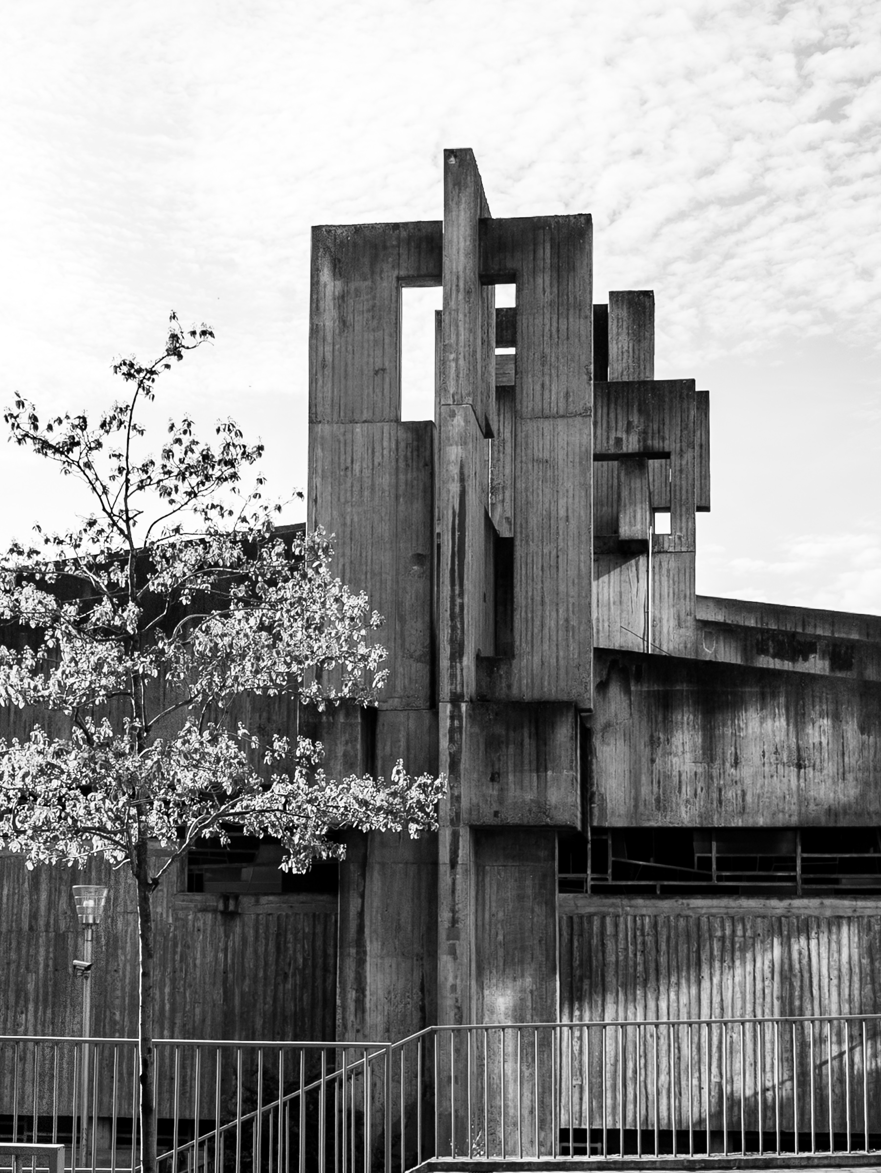 Kirche St. Johannes XXIII Köln — concrete tower element with blooming spring tree in foreground
